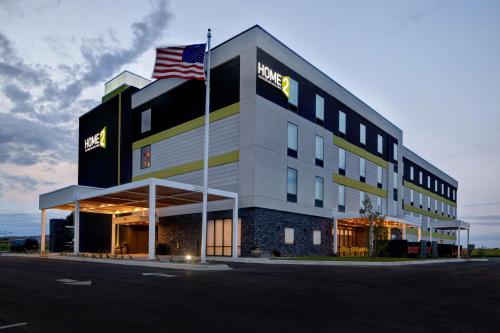 a hotel with an american flag in front of it at Home2 Suites By Hilton Loves Park Rockford in Loves Park