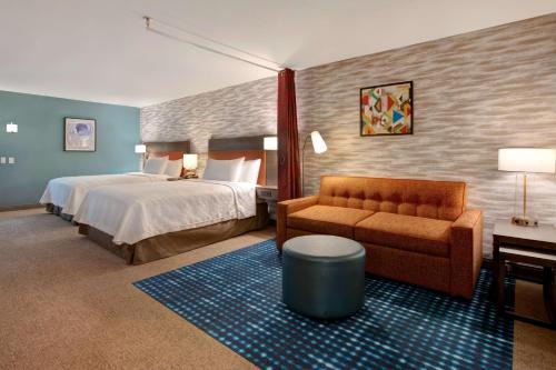 um quarto de hotel com uma cama e um sofá em Home2 Suites By Hilton Loves Park Rockford em Loves Park