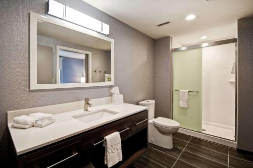 a bathroom with a sink and a toilet and a mirror at Home2 Suites By Hilton Georgetown in Georgetown