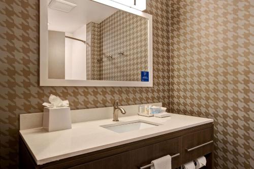 a bathroom with a sink and a mirror at Home2 Suites By Hilton Loves Park Rockford in Loves Park