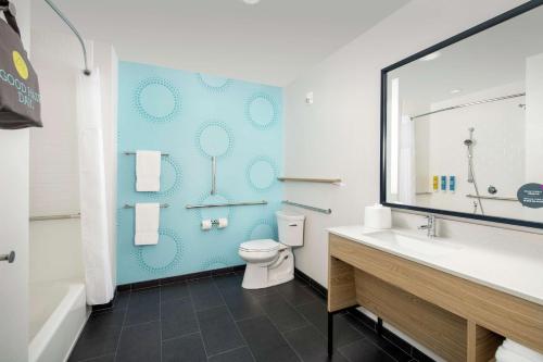 a bathroom with a toilet and a blue wall at Tru By Hilton Lake City in Lake City