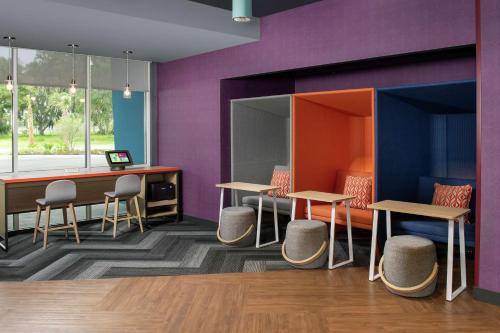 a waiting room with purple walls and tables and chairs at Tru By Hilton Lake City in Lake City