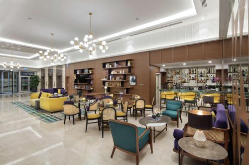 a lobby with chairs and tables and a library at Doubletree By Hilton Afyonkarahisar in Afyon