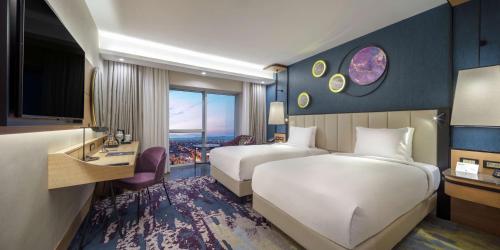 a hotel room with two beds and a television at Doubletree By Hilton Afyonkarahisar in Afyon