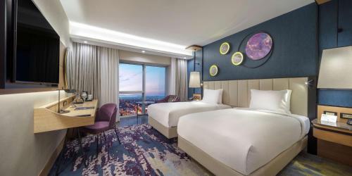 阿菲永Doubletree By Hilton Afyonkarahisar的有两张床和一台电视的酒店房间