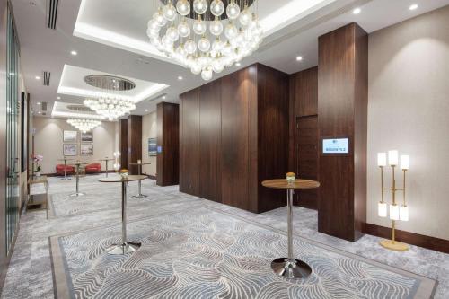 a lobby with two tables and a chandelier at Doubletree By Hilton Afyonkarahisar in Afyon