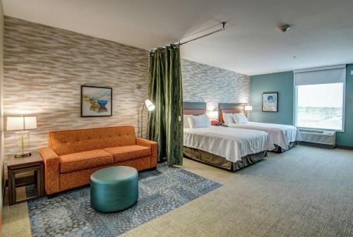 a hotel room with a bed and a couch at Home2 Suites By Hilton Foley in Foley