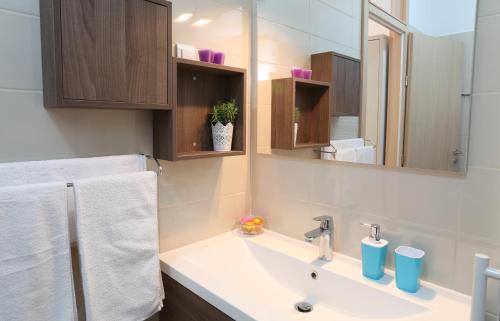 een badkamer met een wastafel en een spiegel bij Apartments Kamelija in Split