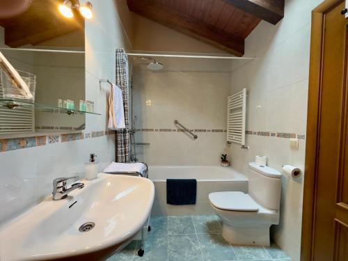 uma casa de banho com um lavatório, um WC e uma banheira em La Llardana em Benasque