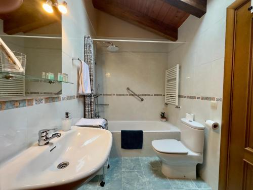 a bathroom with a sink and a toilet and a tub at La Llardana in Benasque