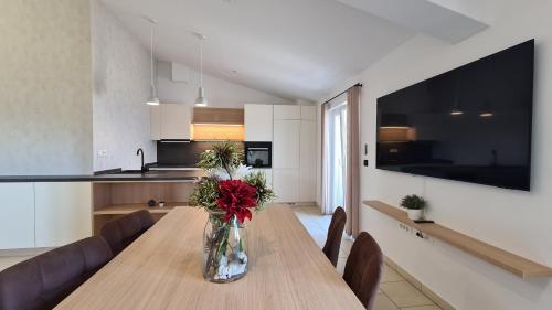 un vase de fleurs sur une table en bois dans une cuisine dans l'établissement Orkula Apartments, à Pašman