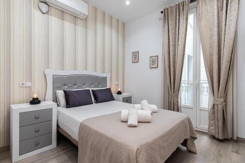 biała sypialnia z 2 łóżkami i oknem w obiekcie BNBHolder Apartamentos en Sol Confort 9 w Madrycie