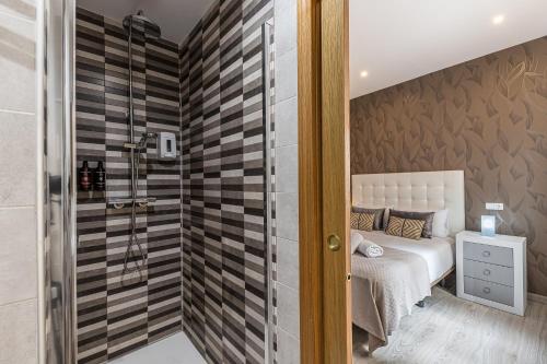 Dormitorio pequeño con cama y ducha en BNBHolder Apartamentos en Sol Confort 9 en Madrid