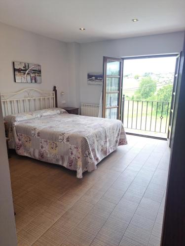 a bedroom with a bed and a sliding glass door at LOS LAURELES in Cudón