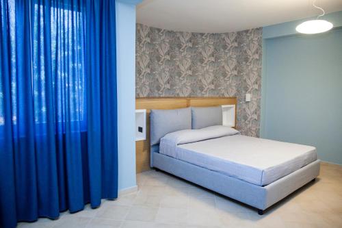 カッシーノにあるLe Colonneのベッドルーム(ベッド1台、青いカーテン付)