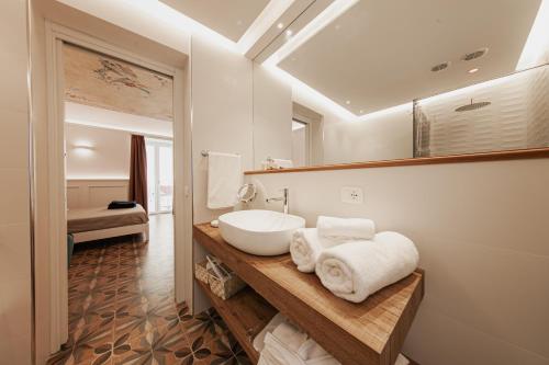 uma casa de banho com um lavatório e um espelho em I Mori Apartments em Cefalù