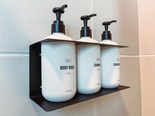 three bottles of body mist on a shelf in a bathroom at Dreaming With Dolly - Luxe Stay Near Broadway in Nashville