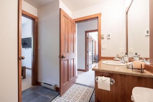 a bathroom with a sink and a mirror at Taluswood Bluffs by Outpost Whistler in Whistler