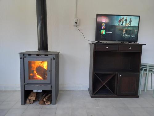 chimenea con TV y TV en la parte superior en Cómoda casa en El Volcan en San Luis