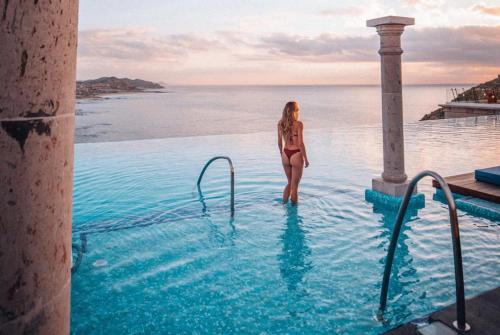 una mujer en bikini parada en una piscina en Beautiful & Spacious 2BR with Terrace - Cabo, en Cabo San Lucas