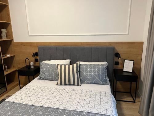 łóżko z niebiesko-białą pościelą i poduszkami w obiekcie Apartments Mrdak w Barze