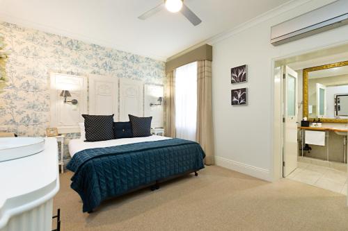 ein Schlafzimmer mit einem Bett und ein Badezimmer mit einem Waschbecken in der Unterkunft Twelve on Albert in Beechworth