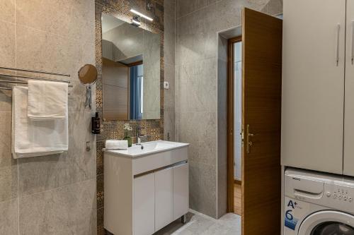 y baño con lavabo y lavadora. en BNBHolder Apartamentos en Sol Confort 3 en Madrid