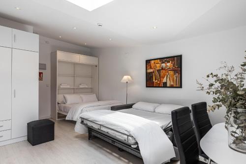 2 camas en una habitación con paredes blancas en BNBHolder Apartamentos en Sol Confort 1, en Madrid
