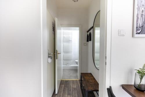 um corredor com uma casa de banho com um lavatório e um espelho em Perfekt für 2! Wifi/ Netflix em Duisburg
