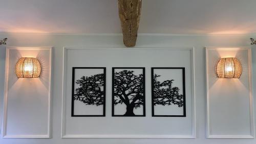three framed picture of a tree on a wall with lights at Siedlisko pod Kasztanem in Garwolin