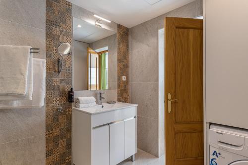 a bathroom with a white sink and a mirror at BNBHolder Apartamentos en Sol Confort 2 in Madrid