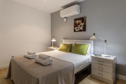 sypialnia z łóżkiem z zielonymi poduszkami w obiekcie BNBHolder Apartamentos en Sol Confort 2 w Madrycie