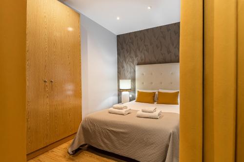 1 dormitorio con 1 cama con 2 toallas en BNBHolder Apartamentos en Sol Superior 1 en Madrid
