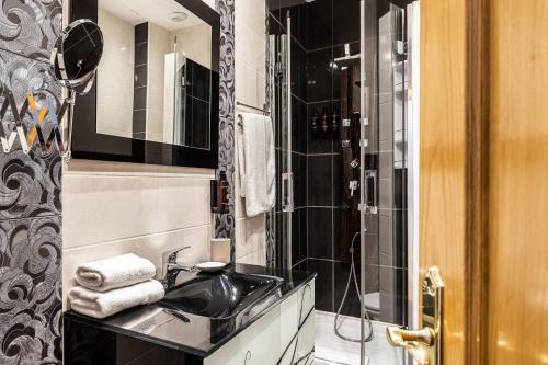 uma casa de banho com um lavatório e um chuveiro em BNBHolder Apartamentos en Sol Superior 1 em Madri