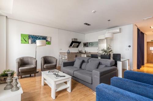 uma sala de estar com um sofá e duas cadeiras em BNBHolder Apartamentos en Sol Deluxe 3 em Madrid
