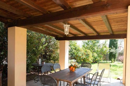 drewniany stół i krzesła pod drewnianą pergolą w obiekcie La casa al Lago w mieście Trevignano Romano