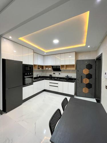 uma cozinha com armários brancos e uma mesa com cadeiras em Royal Rif Al Hoceima em Al Hoceïma