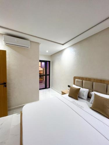 una camera da letto con un grande letto bianco in una stanza di Royal Rif Alhoceima ad Al-Ḥoseyma