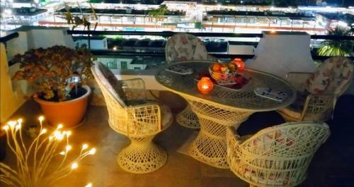 a glass table and chairs with lights on a balcony at Most sunny days on Gran Canaria in Puerto Rico de Gran Canaria