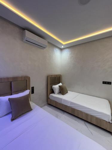 two beds in a room with white sheets and pillows at Royal Rif Alhoceima in Al Hoceïma