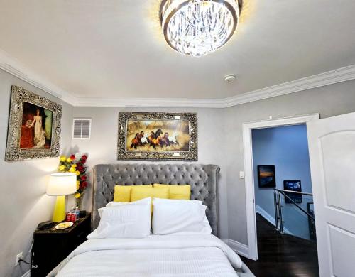 Un dormitorio con una cama grande y una lámpara de araña. en Lilen's Home en Toronto