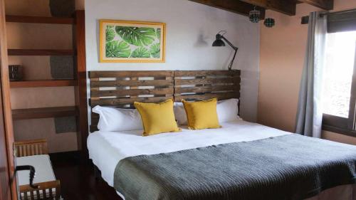 a bedroom with a large bed with yellow pillows at Casa Daniela en la Asomada in La Asomada
