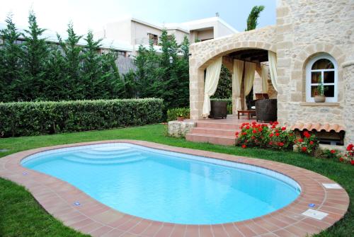 a swimming pool in the yard of a house at Rock House's Villa Melody in Plataniás