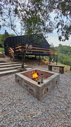 a fire pit in a park with a bench and a playground at Cabaña La escondida - JuJuy- in San Salvador de Jujuy
