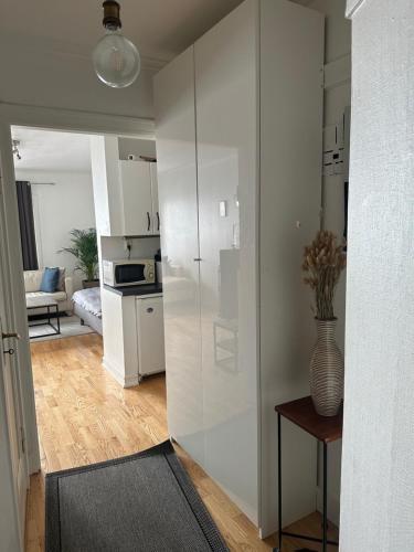 a living room with a white refrigerator and a kitchen at 35m2 apartment in central oslo in Oslo