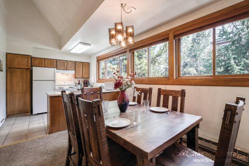 a kitchen with a wooden table with chairs and a dining room at A Perfect Location Walk to EVERYTHING Onsite Hot Tubs Grill And Pool SH52 in Breckenridge