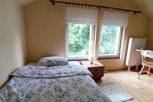 1 dormitorio con 2 camas y 2 ventanas en Trzemcha en Tuchów