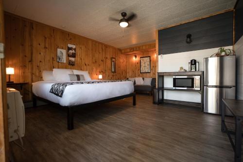 a bedroom with a large bed and a refrigerator at Columbia Point Resort in Kettle Falls