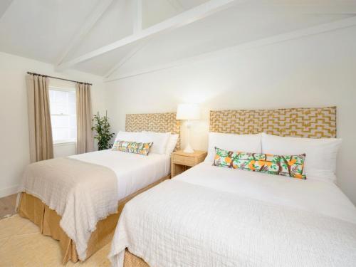 two beds in a room with white walls at Farmhouse Paso in Paso Robles