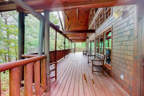 a wooden porch of a house with benches on it at The Lodge at Wears Valley in Sevierville